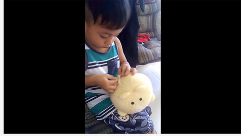 Skillful little boy sews together his damaged stuffed animal