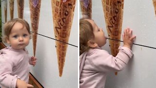 Confused Toddler Tries Licking Picture Of Ice Cream Cone