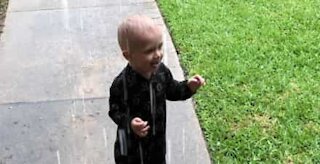 Boy plays in rain for the first time