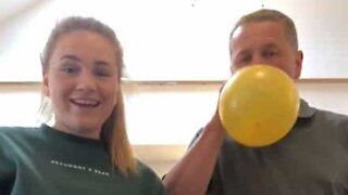 Dad and daughter sing using helium