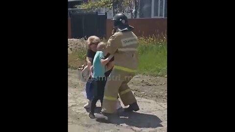 A child is rescued from a burning house in Makeevka after it was hit by a Ukrainian Grad MLRS