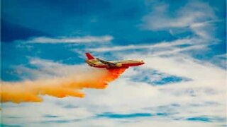 Fire-fighting aircraft "paints" house in California