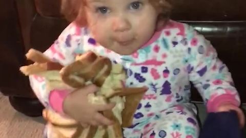 Little Girl Crawls Around Eating and Holding Onto Bread