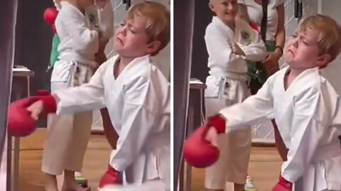 Kid clearly not too thrilled to be at kickboxing class