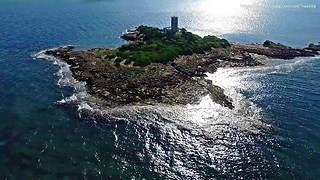 Lonely lighthouse island in Greece seen from drone