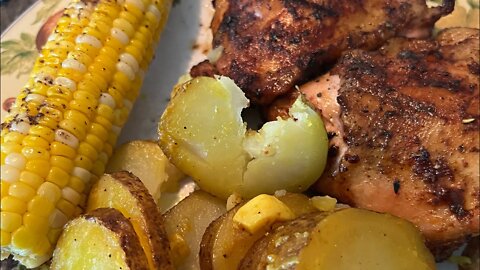 The finished grilled chicken, corn and potatoes all on the Barbeque