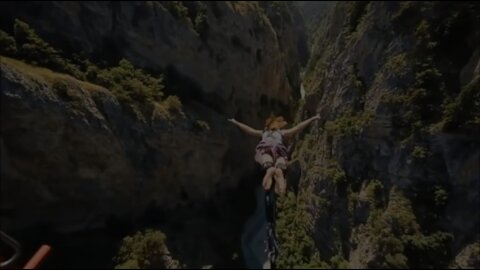 extreme bungee jumping moment from a steep cliff above the river