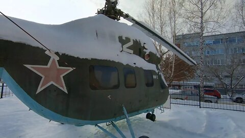 Walking in Siberia. City courtyards of Novosibirsk. There's a helicopter and a dinosaur