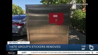 Neighbors quickly rip down white supremacist stickers