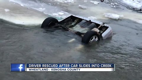 Driver rescued after car slides into creek