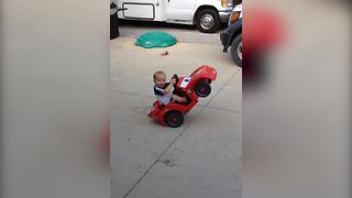 Tot Boy Drives A Toy Car On Its Two Back Wheels