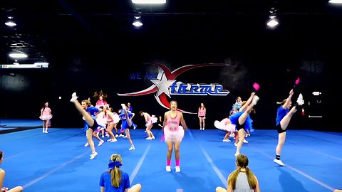 Cheer team use performance for coach's baby gender reveal