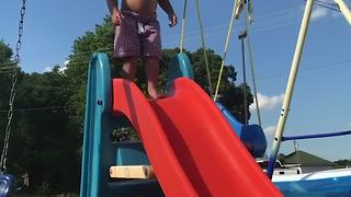 A Tot Boy Jumps Off A Slide