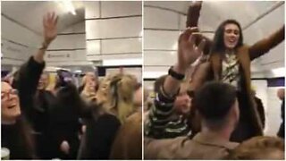 Crowd sings in unison at London underground station