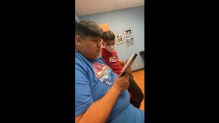 Native Dad reads to son during dr visit