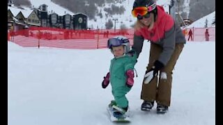One-year old girl goes snowboarding for the first time