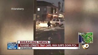 Man surfs flooded street in Oceanside during storm