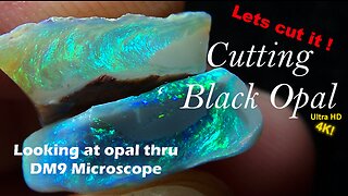 Cutting and polishing black opal rough stone to precious Gemstone Exploring opal thru microscope.