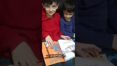 NATAN ( 7 anos) lendo para seu irmão de 4 anos.