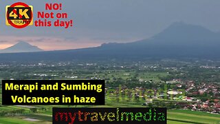 Sumbing, Merapi and Merbabu volcanoes between thunderstorms in late afternoon smoke haze.