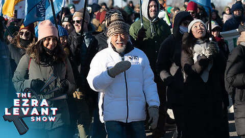 David Suzuki calls the truckers "anarchists" (as he stands by an anarchist flag)