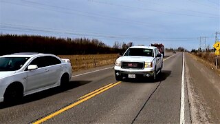 Oncoming truck dangerously squeezes between cyclist and car at high speed