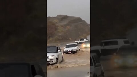 Range rover vogue and other car water crossing Highway