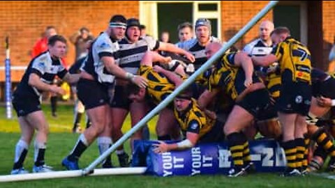 Rugby players knock down a goalpost