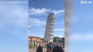 Homem brincalhão dá “high fives” a turistas na Torre de Pisa