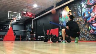 Basketball player slam dunks using slingshot