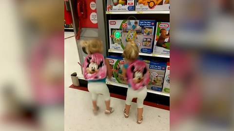 "Twin Girls Dancing Adorably in Toy Store"