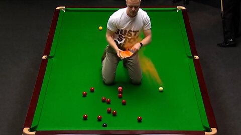 Protester jumps on table at World Snooker Championship, throws orange powder