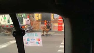 Homem utiliza cadeira de escritório para andar na estrada em Nova Iorque