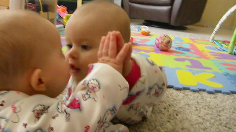 Baby attempts to kiss her own reflection