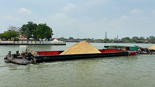 Tugboats and Barge loaded with sand passing at Koh Kret Chao Phraya river Thailand