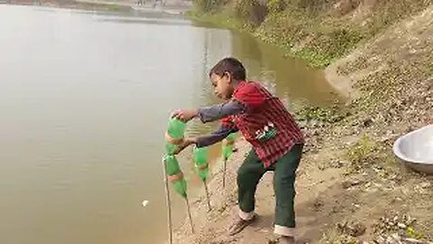 Young boy catching big fishes With plastic bottles