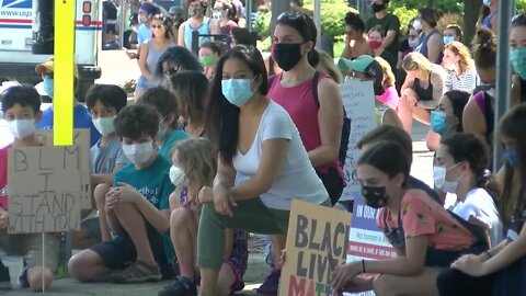 People line the streets of East Aurora to take a knee