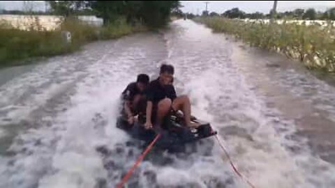 Vesilautailemassa tulvivalla tiellä Thaimaassa