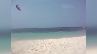 Woman Films A Kite At The Beach Before It Falls On Her And Her Friends.