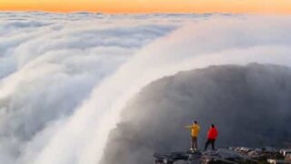 Clouds move down mountain like waterfall