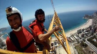 Skydivers fanno bunjee jumping lanciandosi da un edificio in costruzione