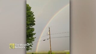 Large rainbow peeks through the rain