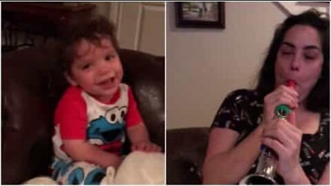 Hilarious baby can't stop laughing at mom playing the flute