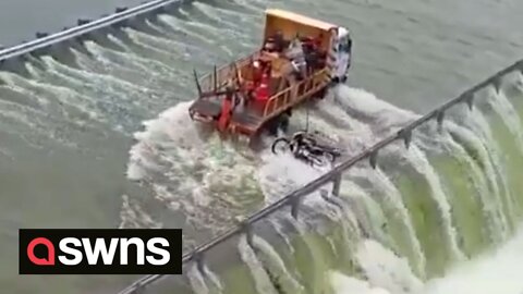 Tense moment police rescue a stranded motorcyclist who got stuck crossing a flooded bridge