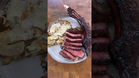 Smoked hanging tomahawks steaks with cheese loaded potatoes