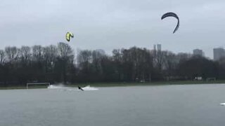 Kitesurfere hygger sig på en oversvømmet fodboldbane