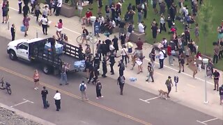 Denver police hands out water bottles to protesters demanding an end to police brutality