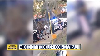 Video: Toddler walks with her hands up toward police officer