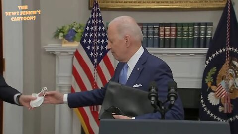 Biden hands a folded white face mask to a masked Breyer, who then puts it in his pocket.