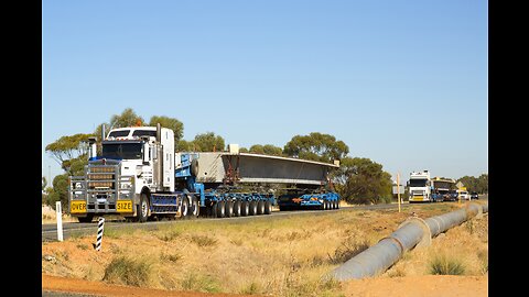 Hugh oversize concrete bridge sections being transported by a Kenworth and Volvo, Western Australia.
